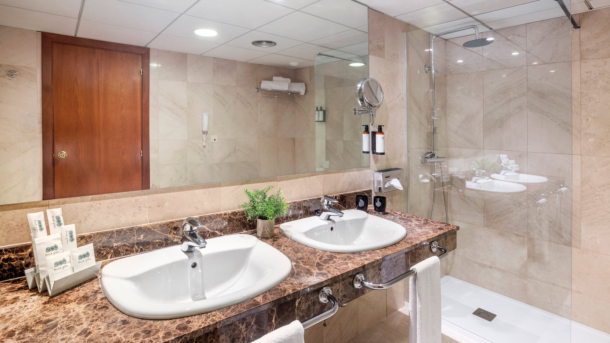a bathroom with marble countertop sinks and shower