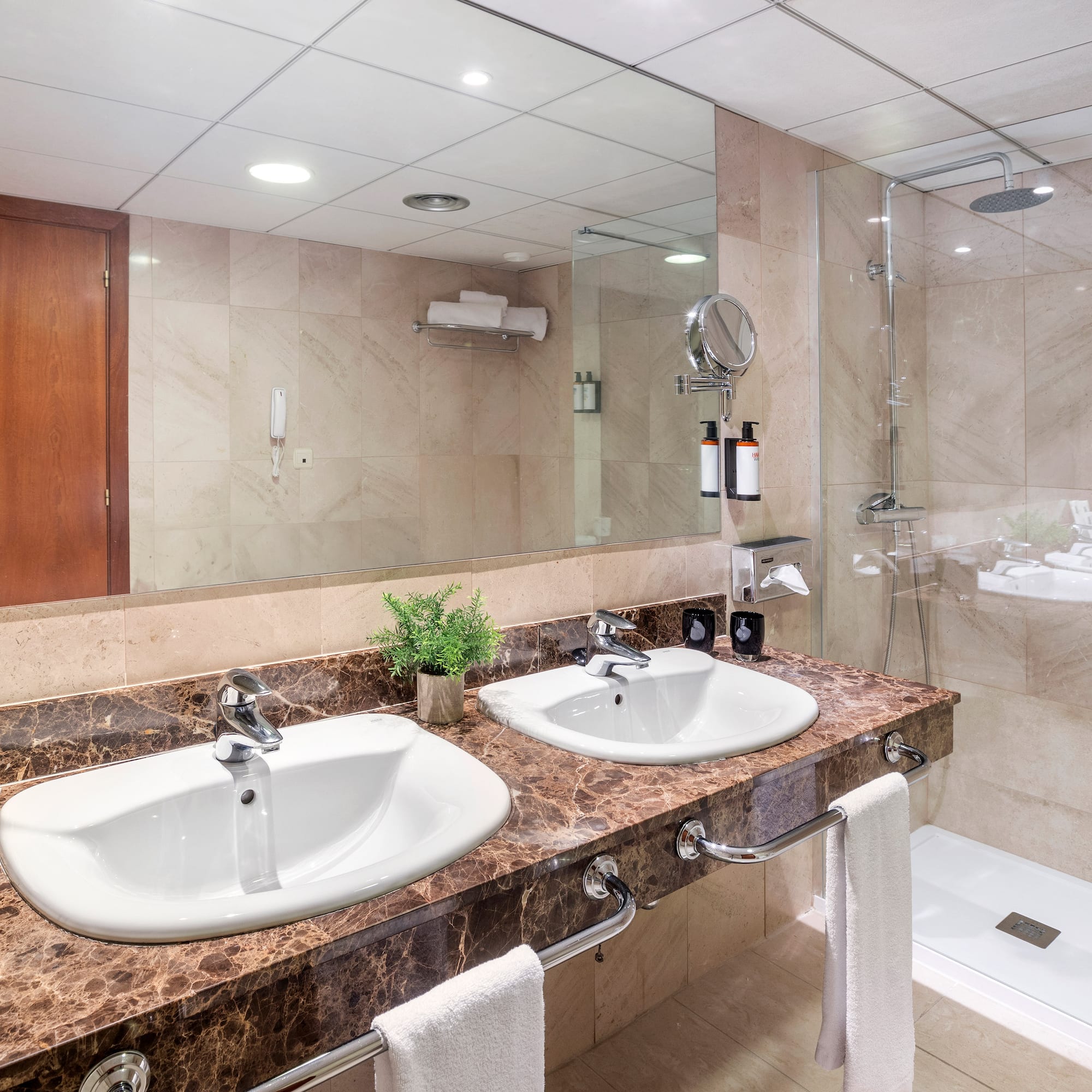 a bathroom with marble countertop sinks and shower