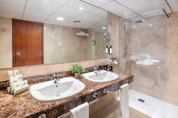 a bathroom with marble countertop sinks and shower