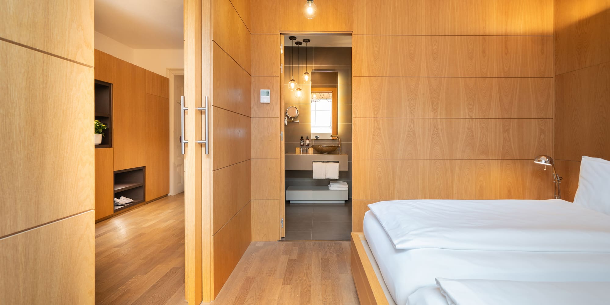 a bedroom with wood paneled walls and a wood floor