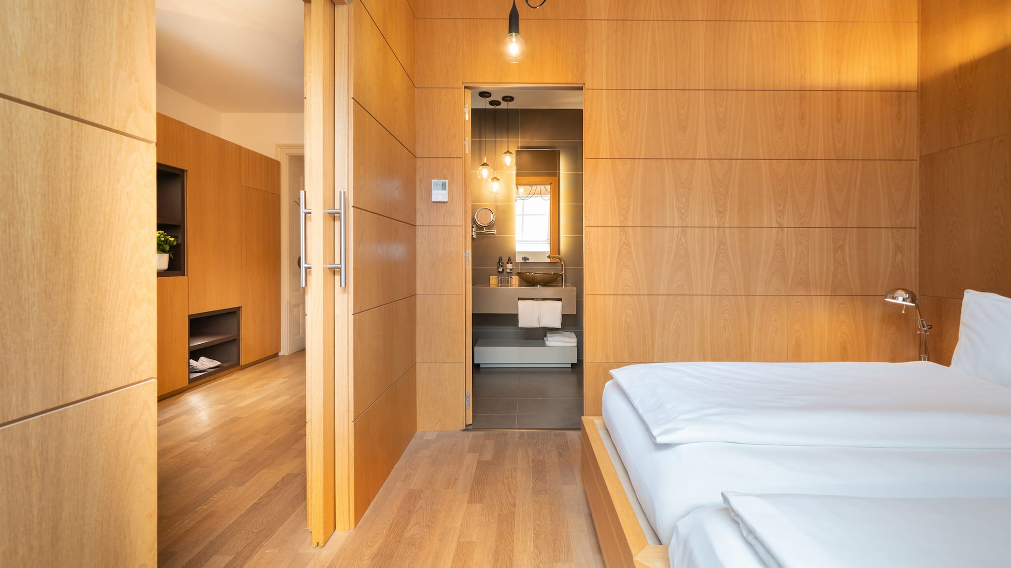 a bedroom with wood paneled walls and a wood floor