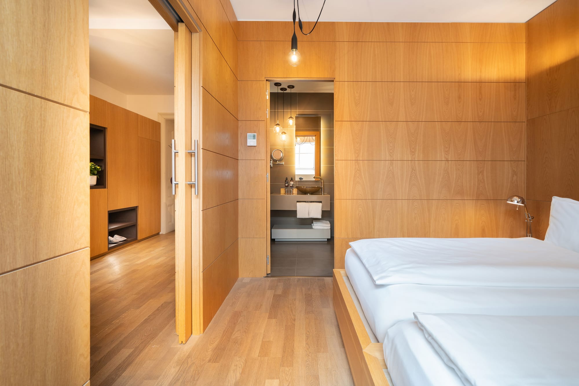 a bedroom with wood paneled walls and a wood floor