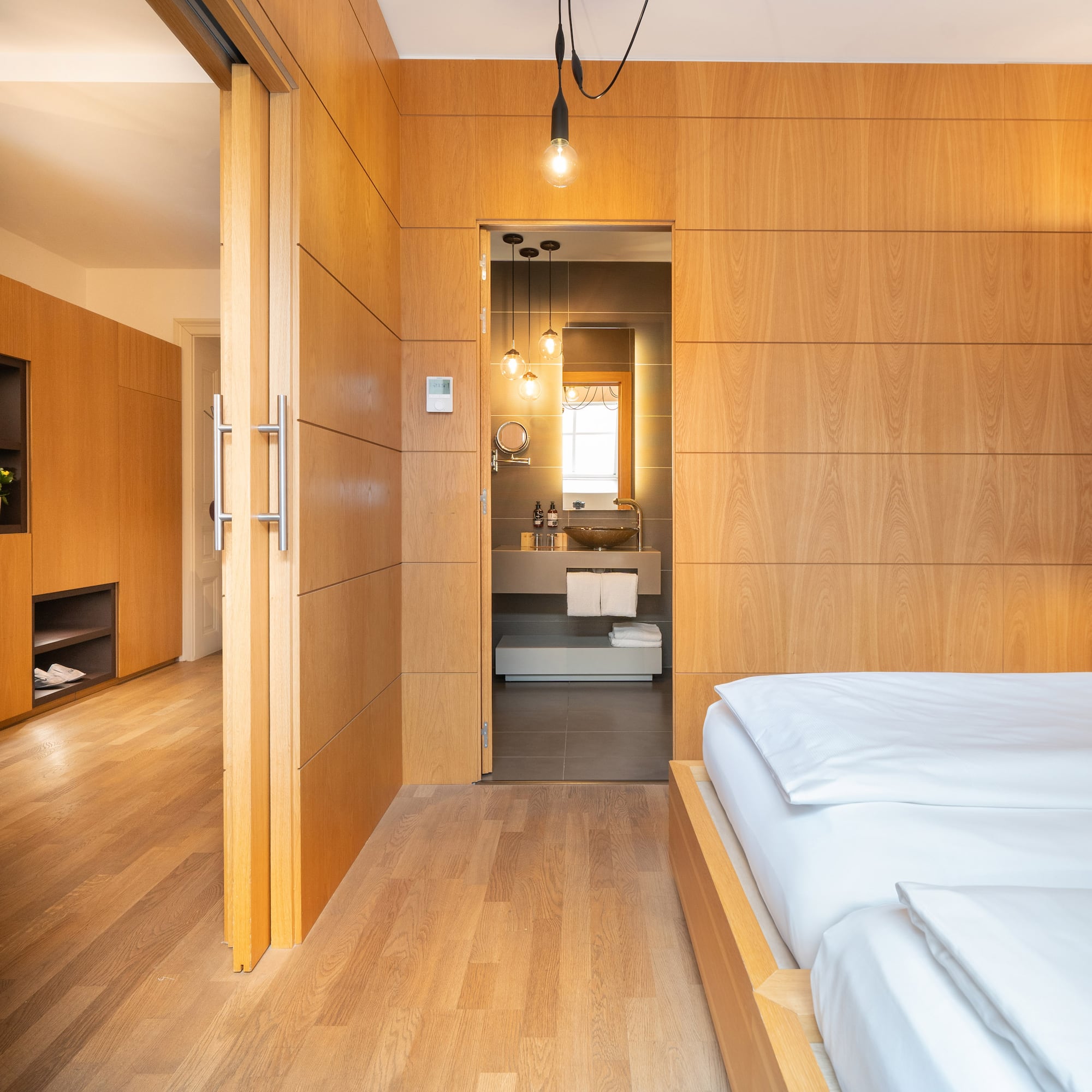 a bedroom with wood paneled walls and a wood floor