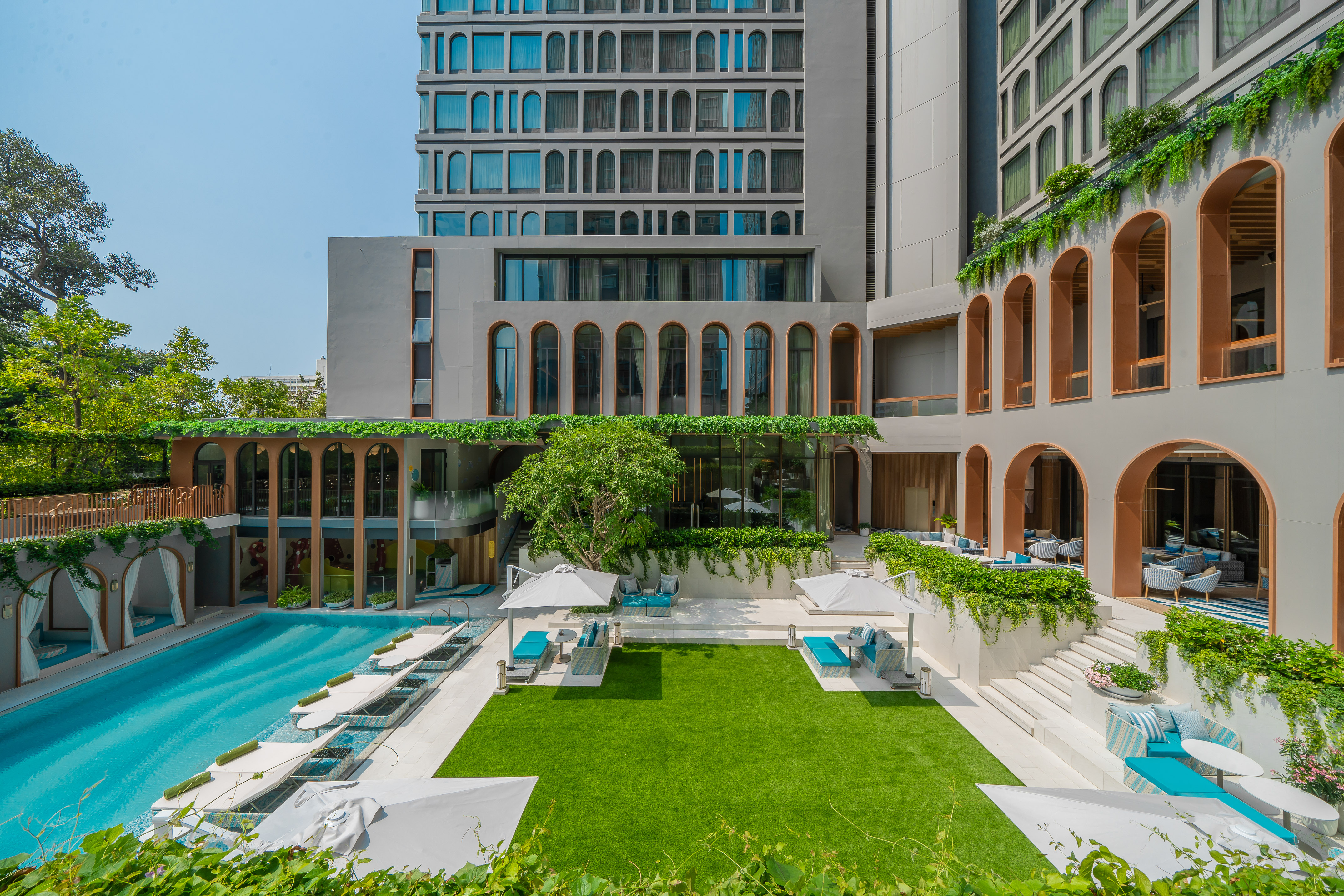 Luxury hotel resort with blue swimming pool, green lawn, and modern arched design. - Một khoảnh khắc sảng khoái - Meliá Pattaya Hotel, Pattaya