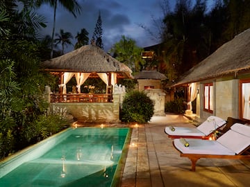 a pool with lounge chairs and a gazebo in the background