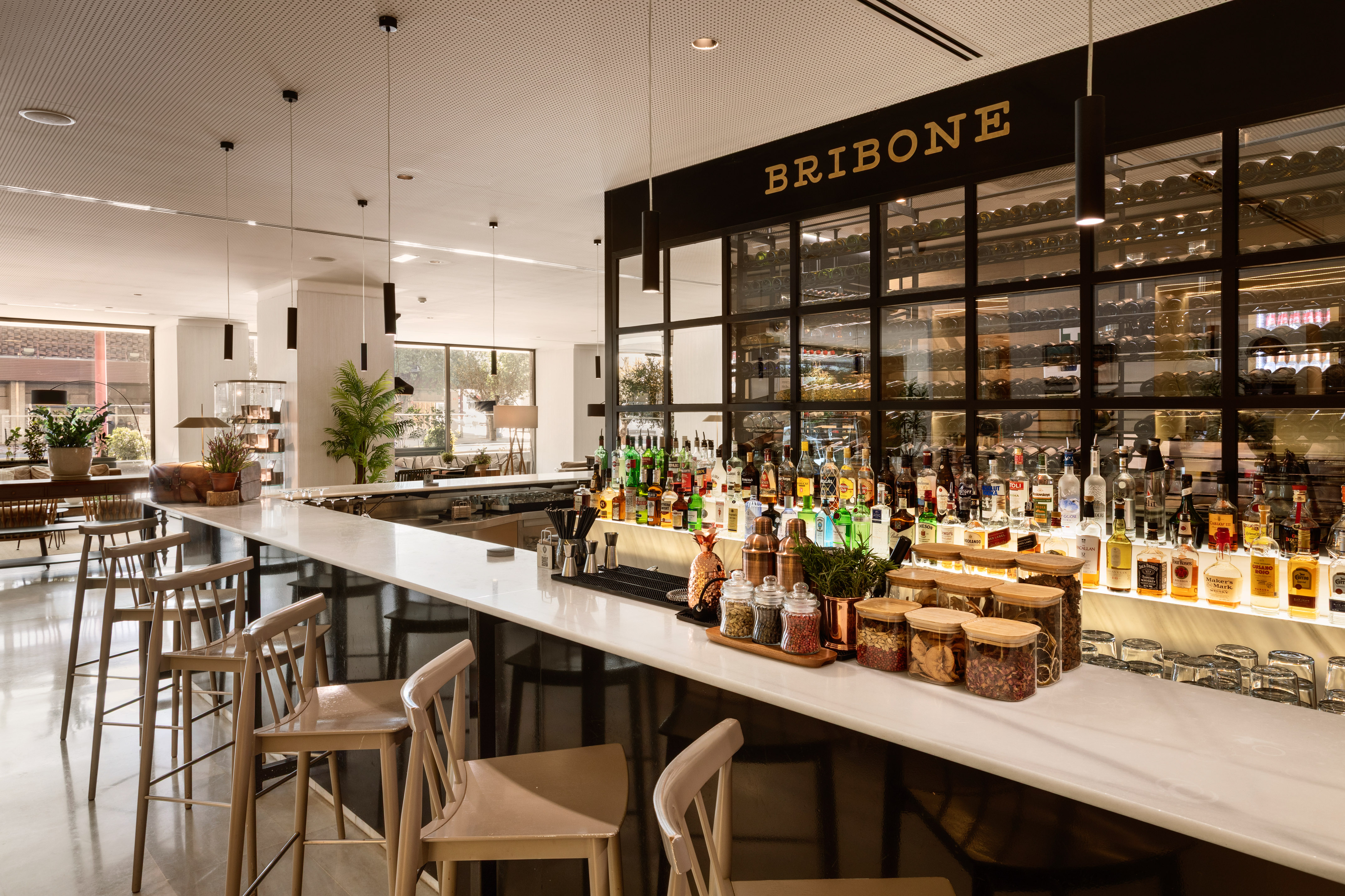 a bar with bottles of liquor and chairs