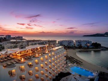 a hotel with a pool and a beach
