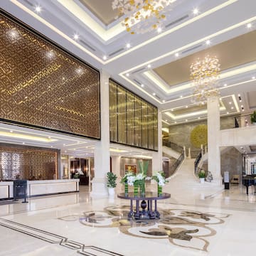 a large lobby with a staircase and a large chandelier