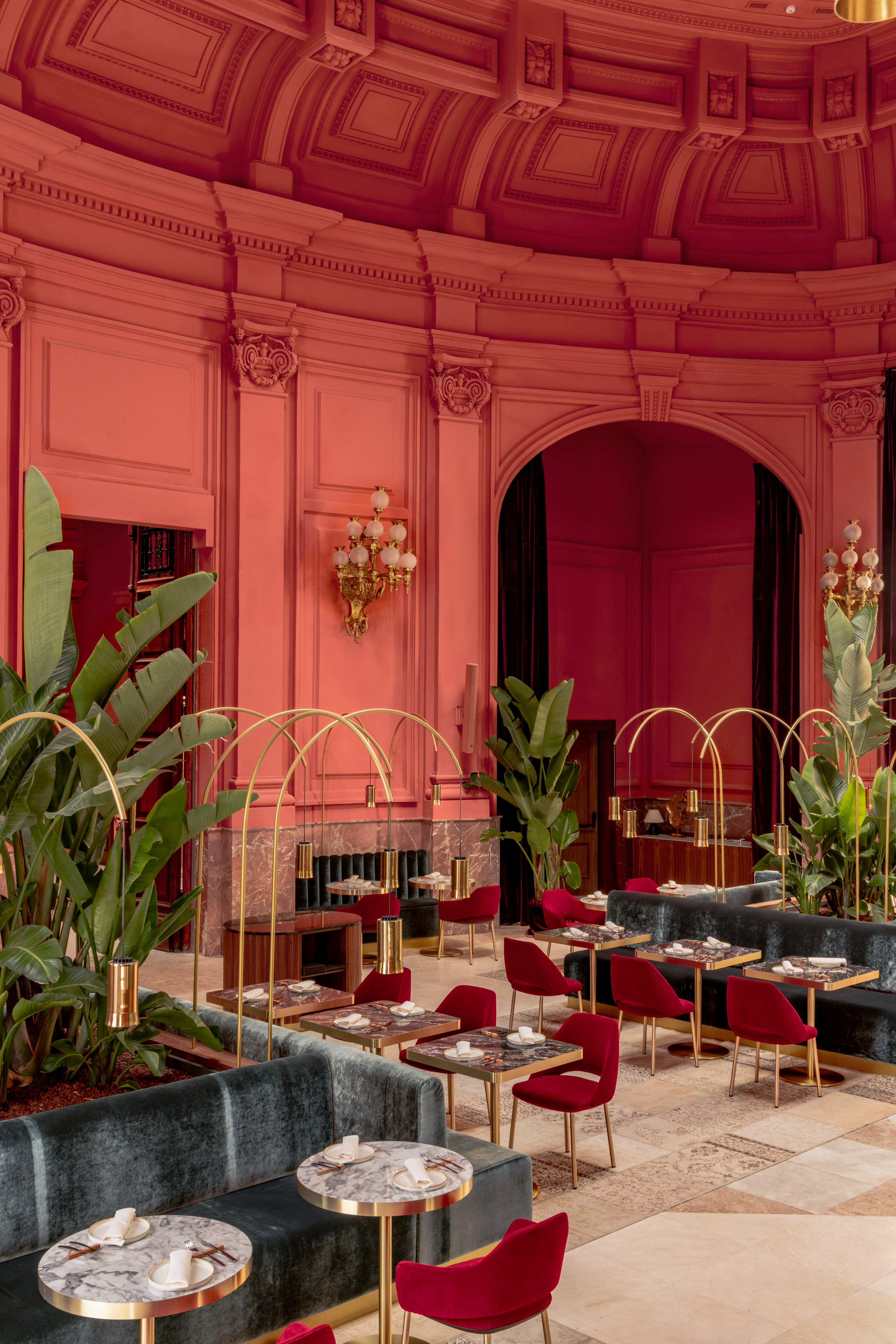 Coral luxury restaurant with velvet seating, marble tables, and gold accents.