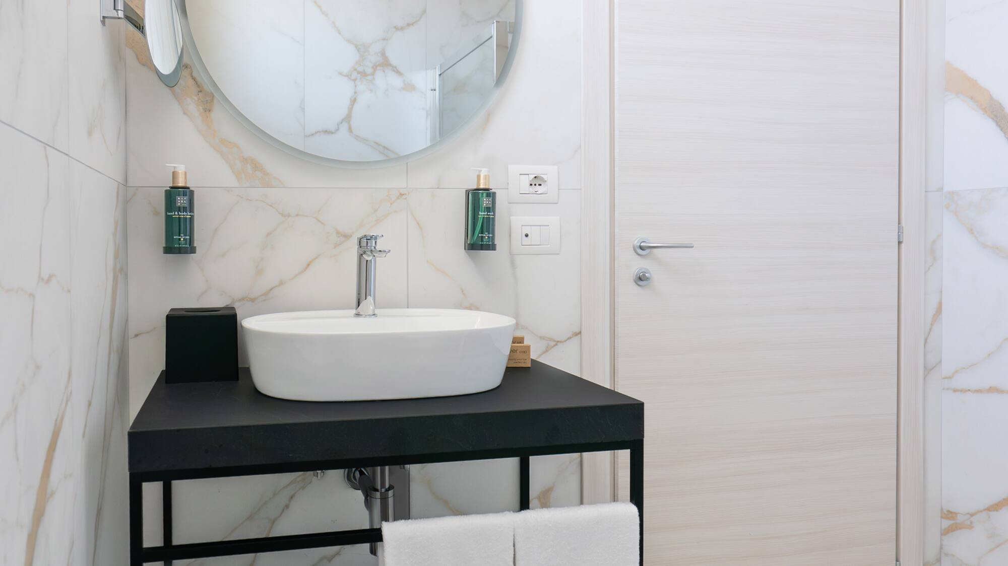 a bathroom with a round mirror and a sink