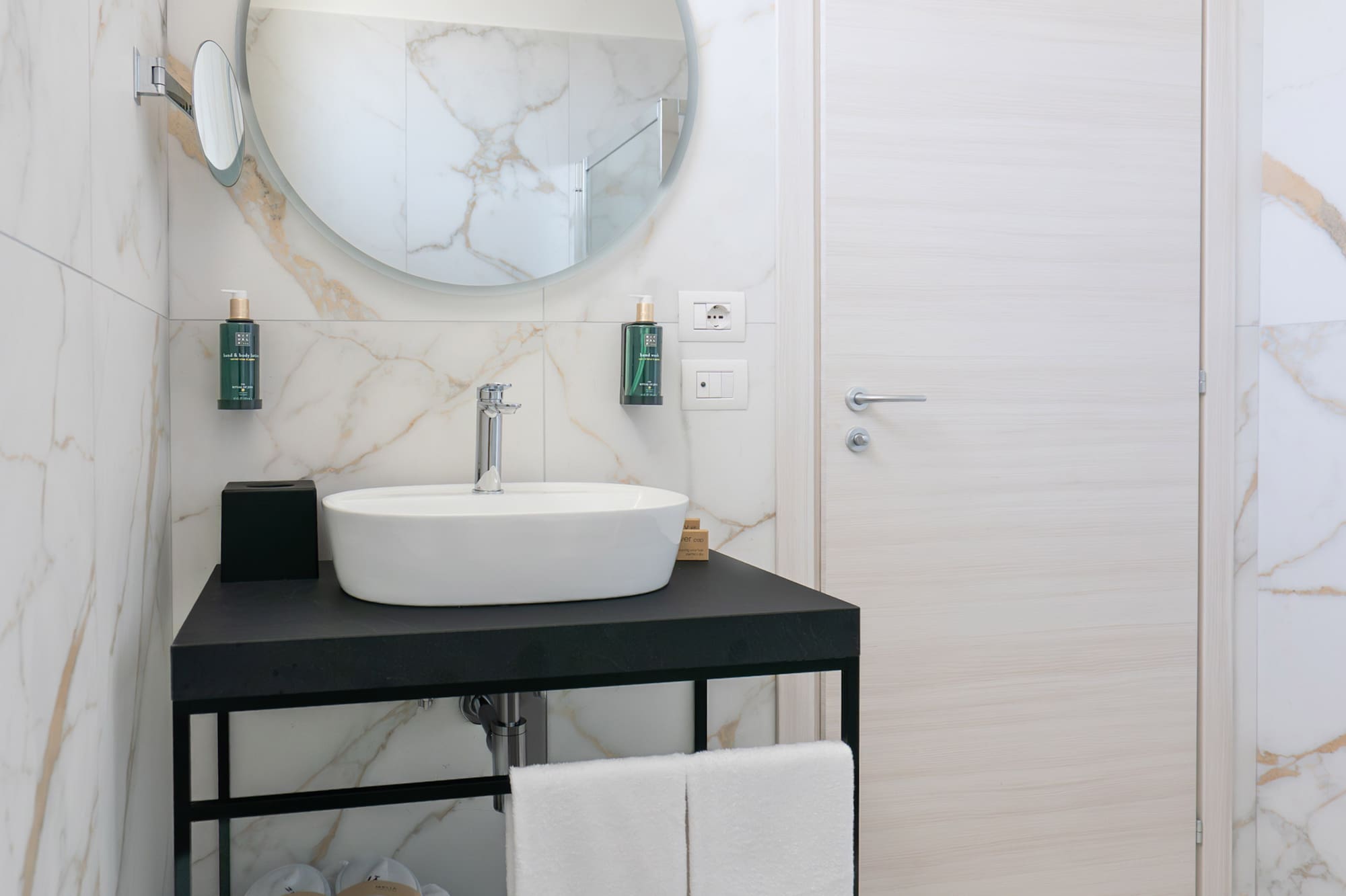 a bathroom with a round mirror and a sink