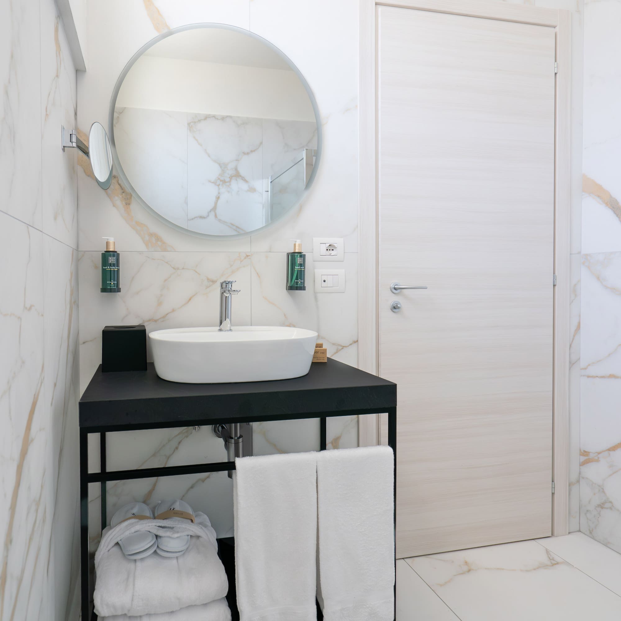 a bathroom with a round mirror and a sink