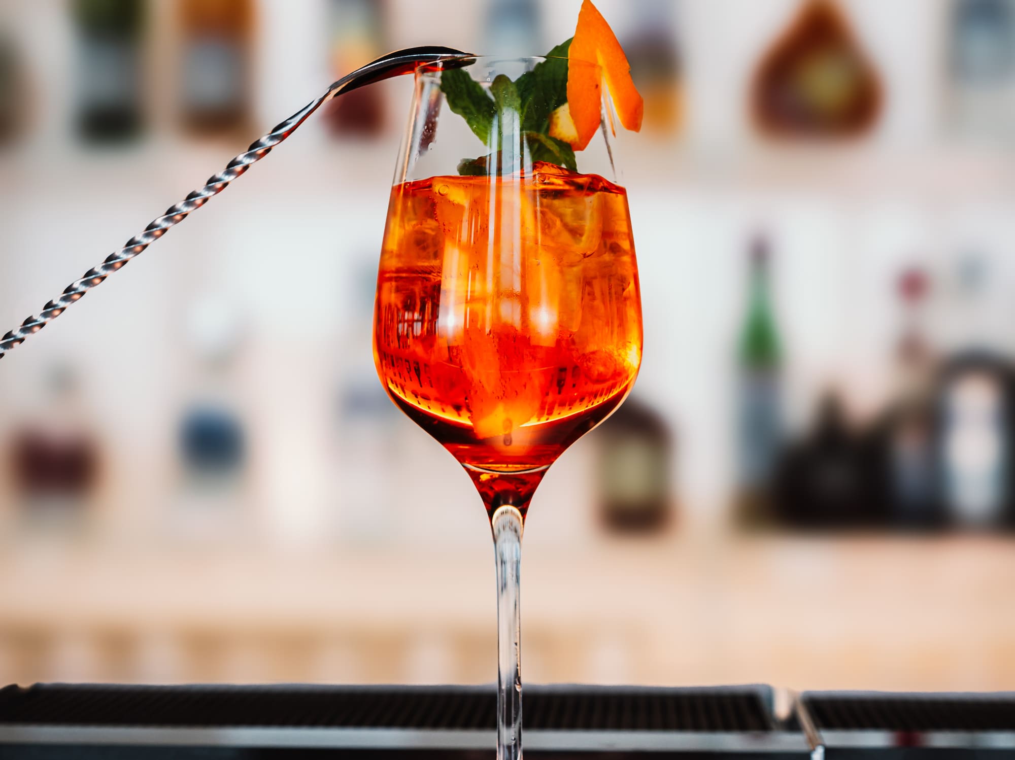 a glass with orange liquid and a spoon