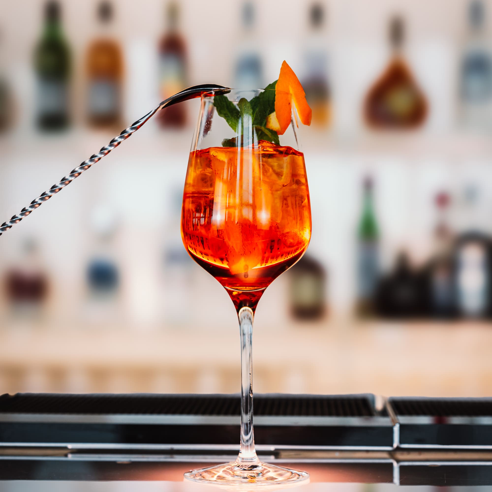 a glass with orange liquid and a spoon
