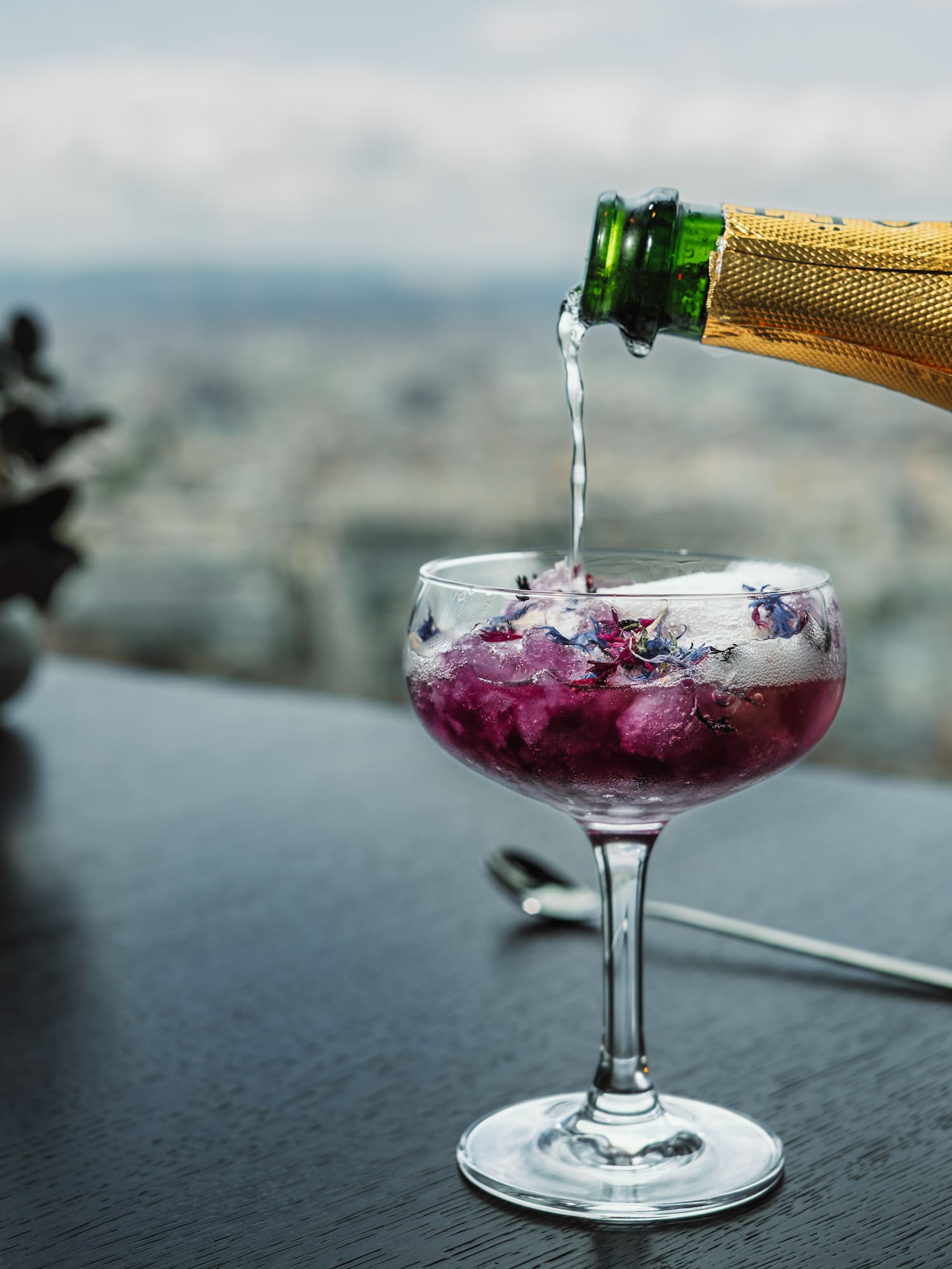 a person pouring a drink into a glass