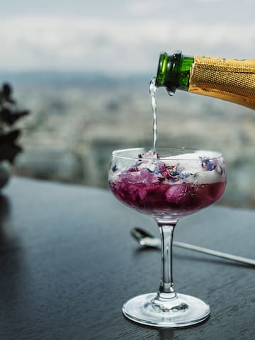 a person pouring a drink into a glass