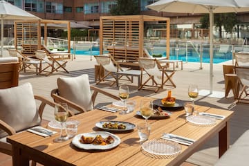 a table with food on it and chairs and a pool in the background