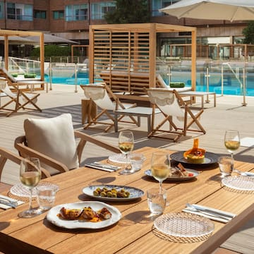 a table with food on it and chairs and a pool in the background