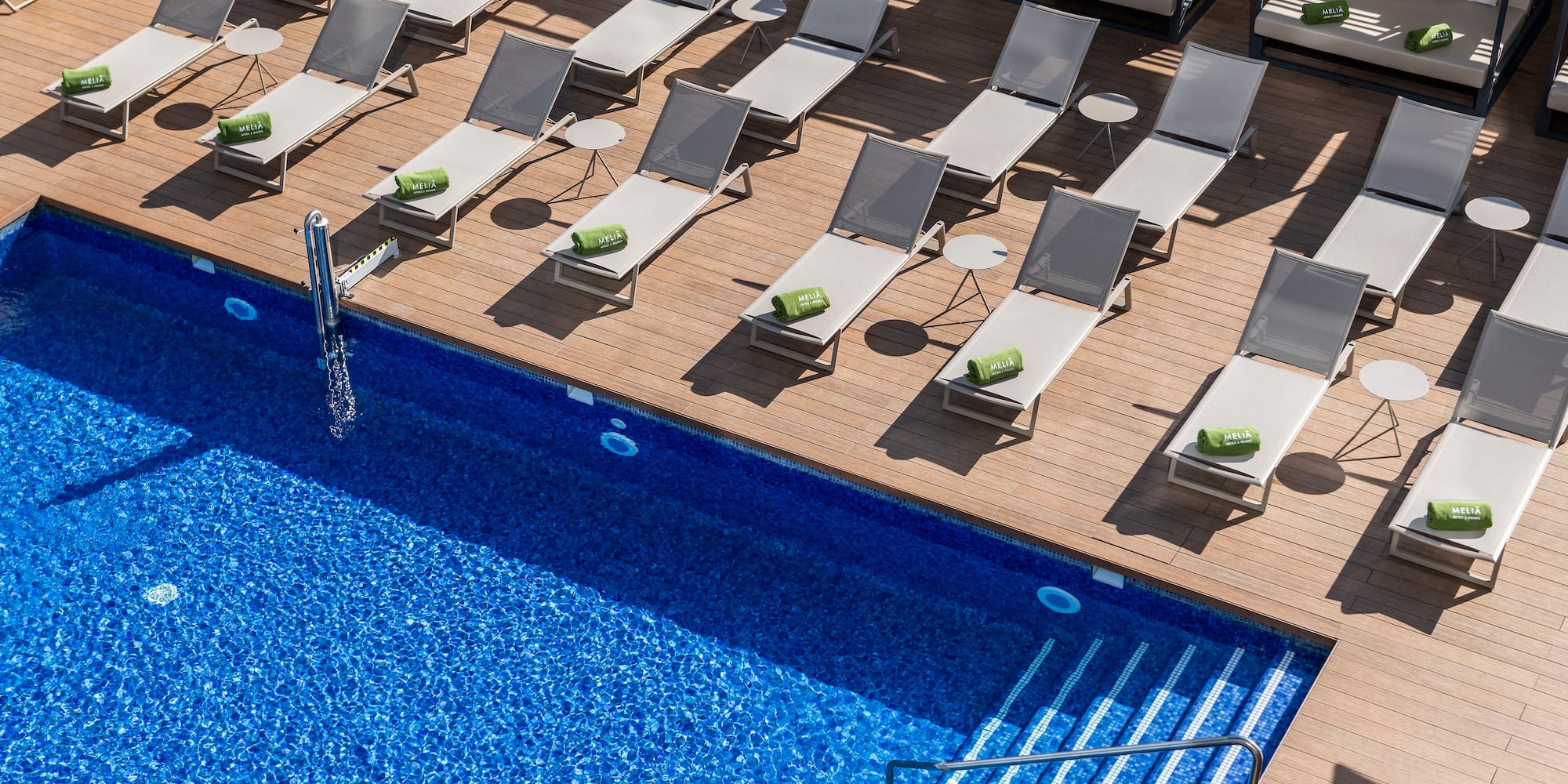 a pool with lounge chairs and a deck