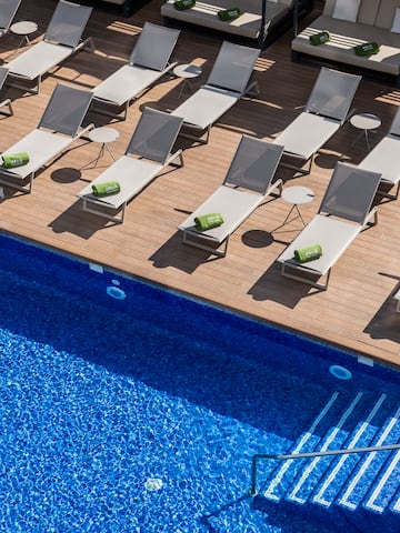 a pool with lounge chairs and a deck