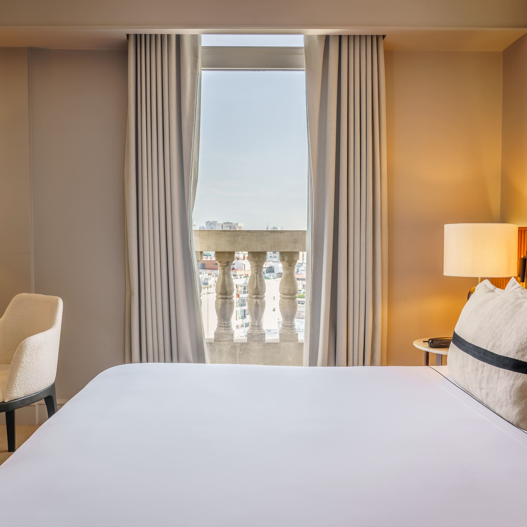 a bed with a lamp and a chair in a hotel room