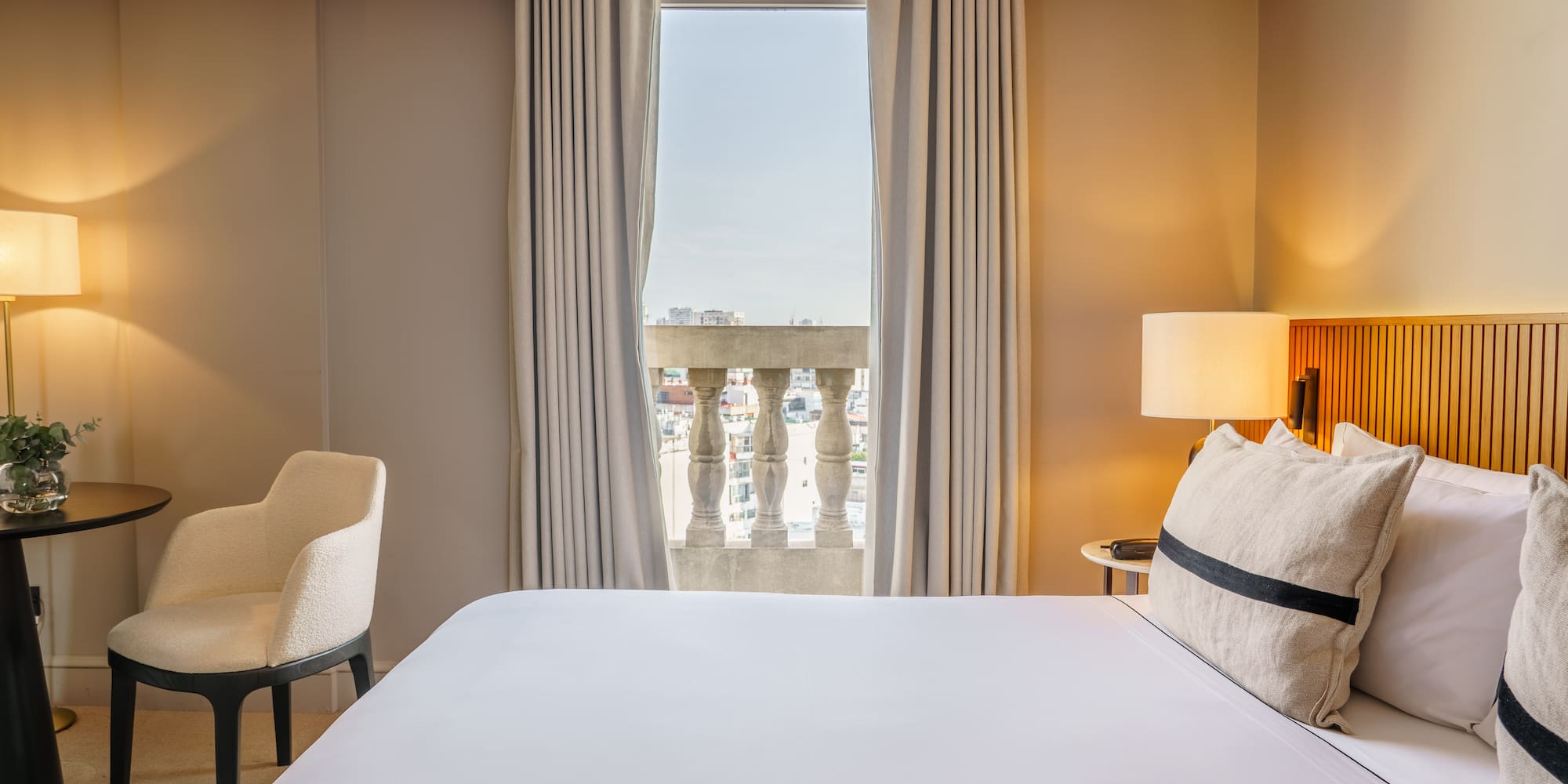 a bed with a lamp and a chair in a hotel room