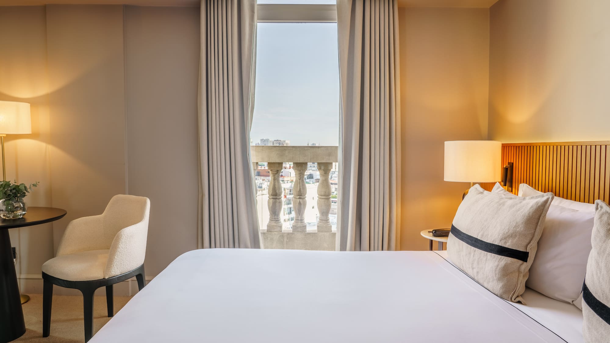 a bed with a lamp and a chair in a hotel room