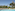 a pool with lounge chairs and trees in the background