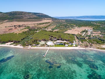 an aerial view of a beach with a pool and trees