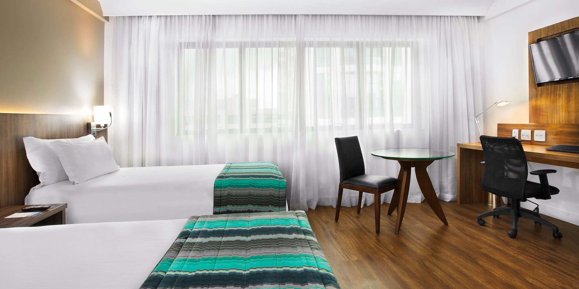 a room with two beds and a desk