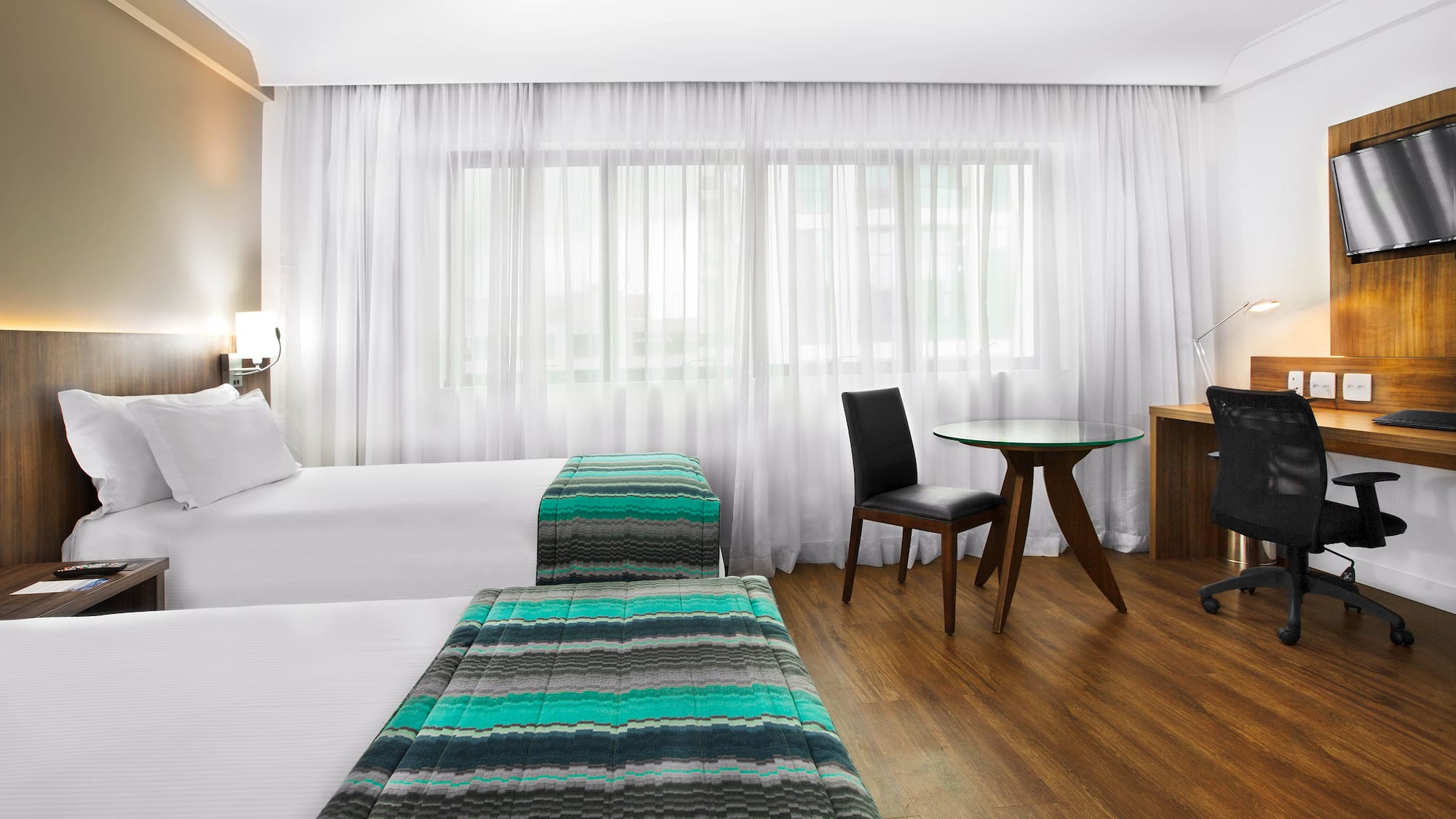 a room with two beds and a desk