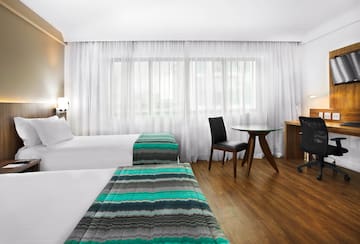 a room with two beds and a desk