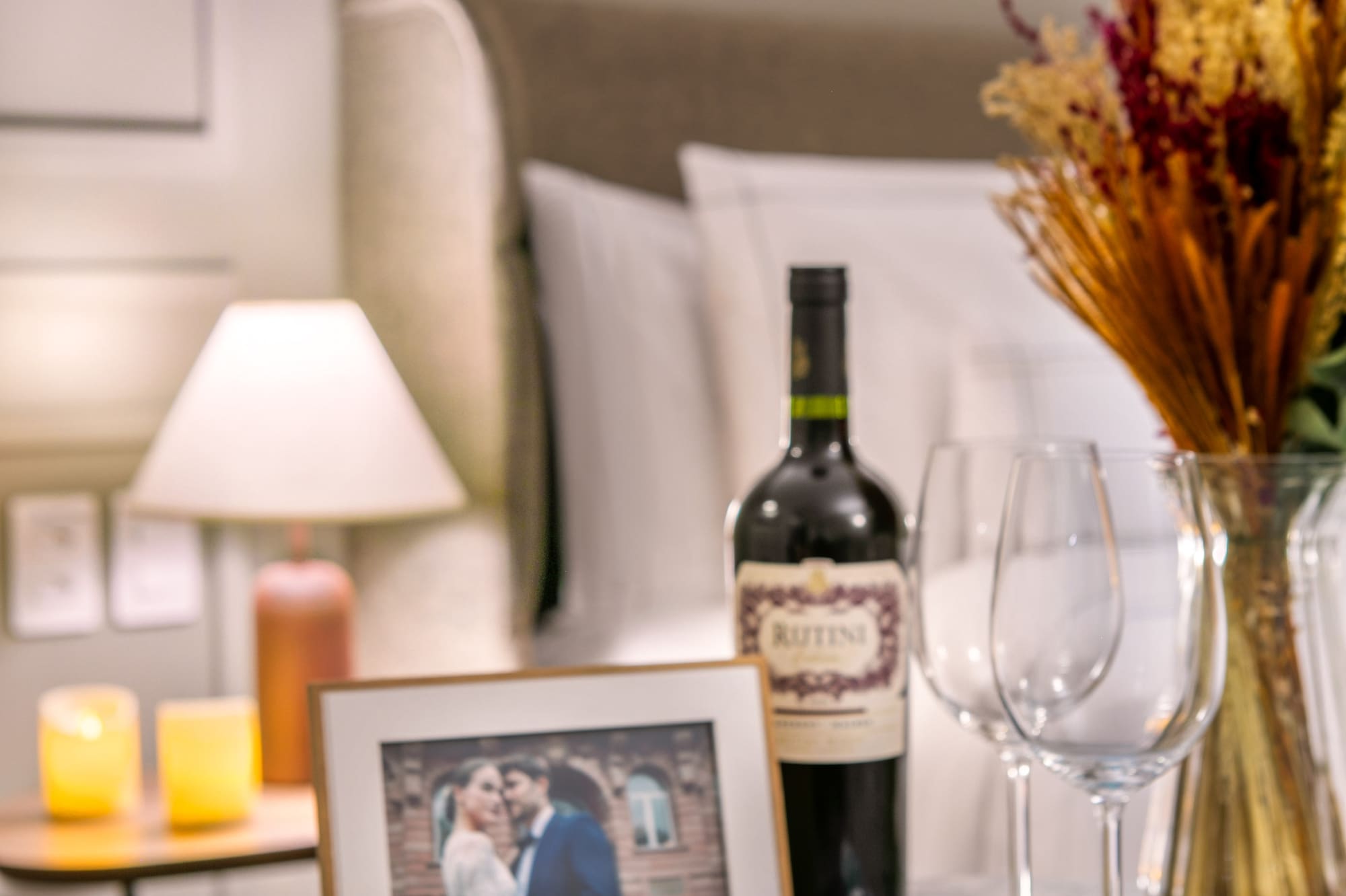 Romantic hotel charcuterie board with wine, cheese, meats, and couple photo.