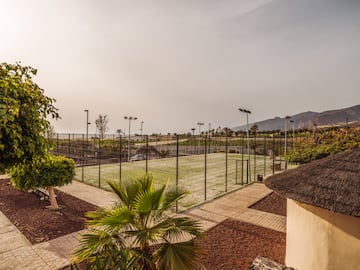 a tennis court with trees and a fence