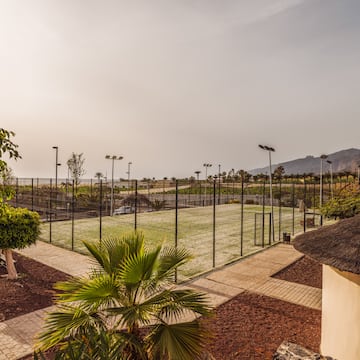 a tennis court with trees and a fence