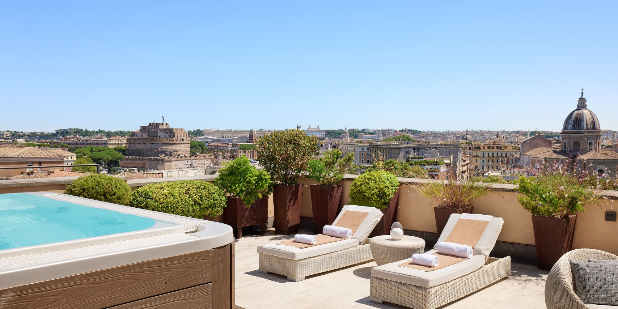 a hot tub and lounge chairs on a rooftop