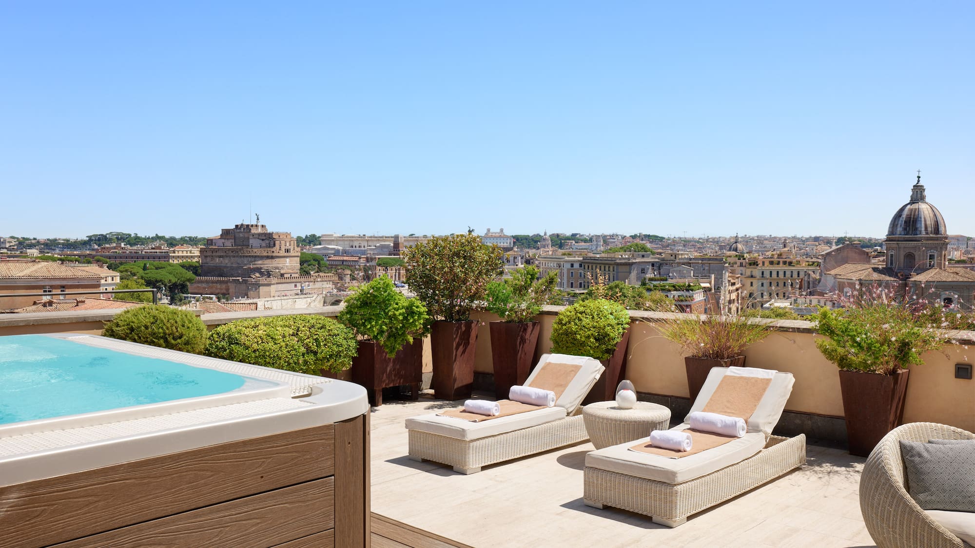 a hot tub and lounge chairs on a rooftop