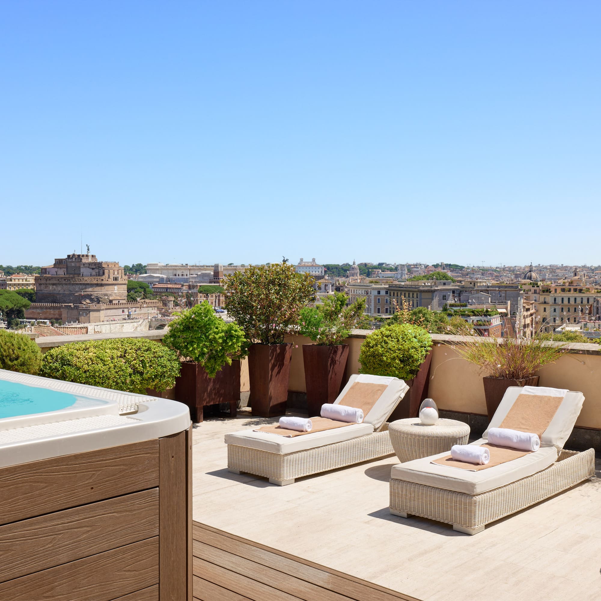 a hot tub and lounge chairs on a rooftop