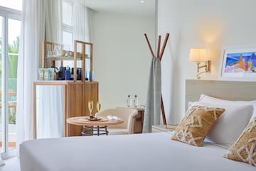 a room with a bed and a table with wine glasses
