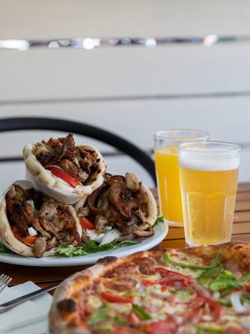 a plate of food and two glasses of beer