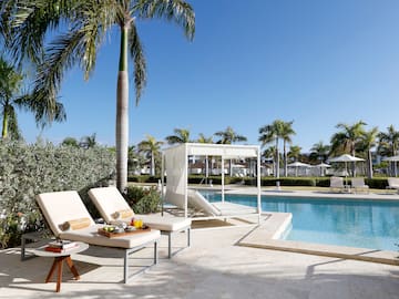 a pool with lounge chairs and palm trees