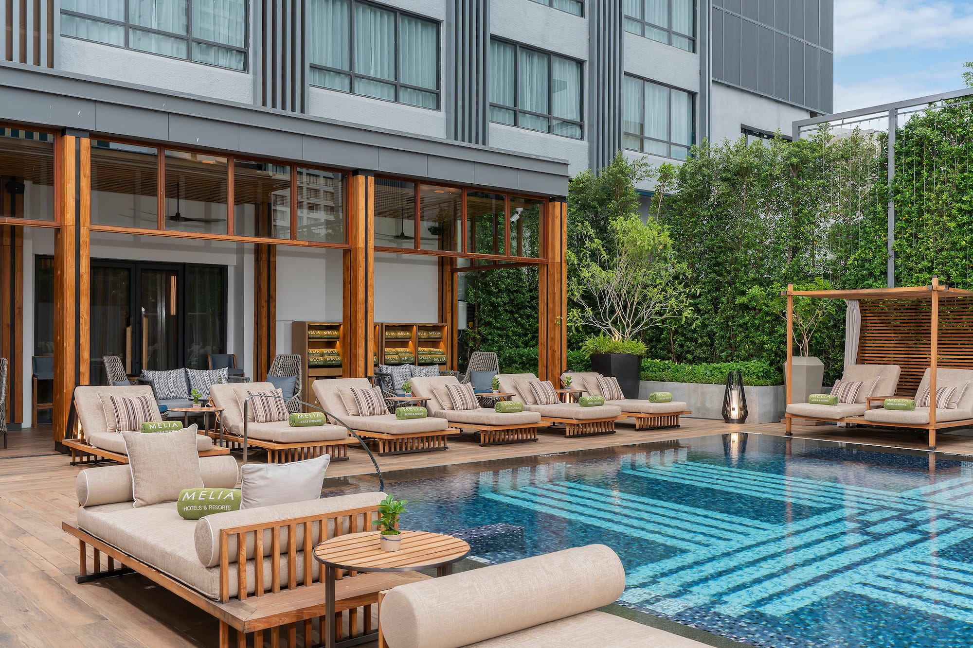 Melia hotel outdoor pool deck with modern lounge chairs and daybeds.