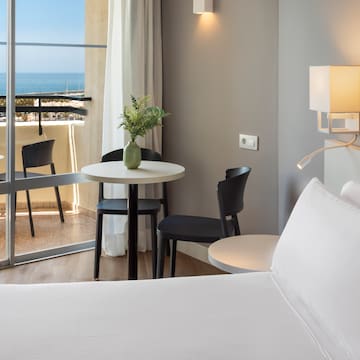 a room with a bed and table and chairs