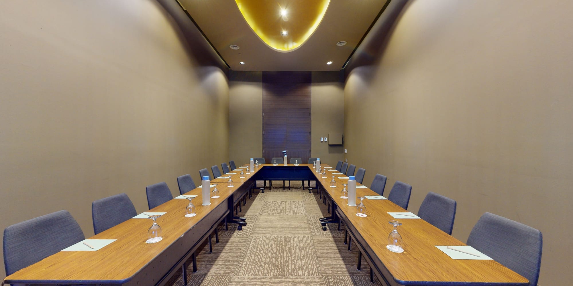 a long table with chairs and glasses on it