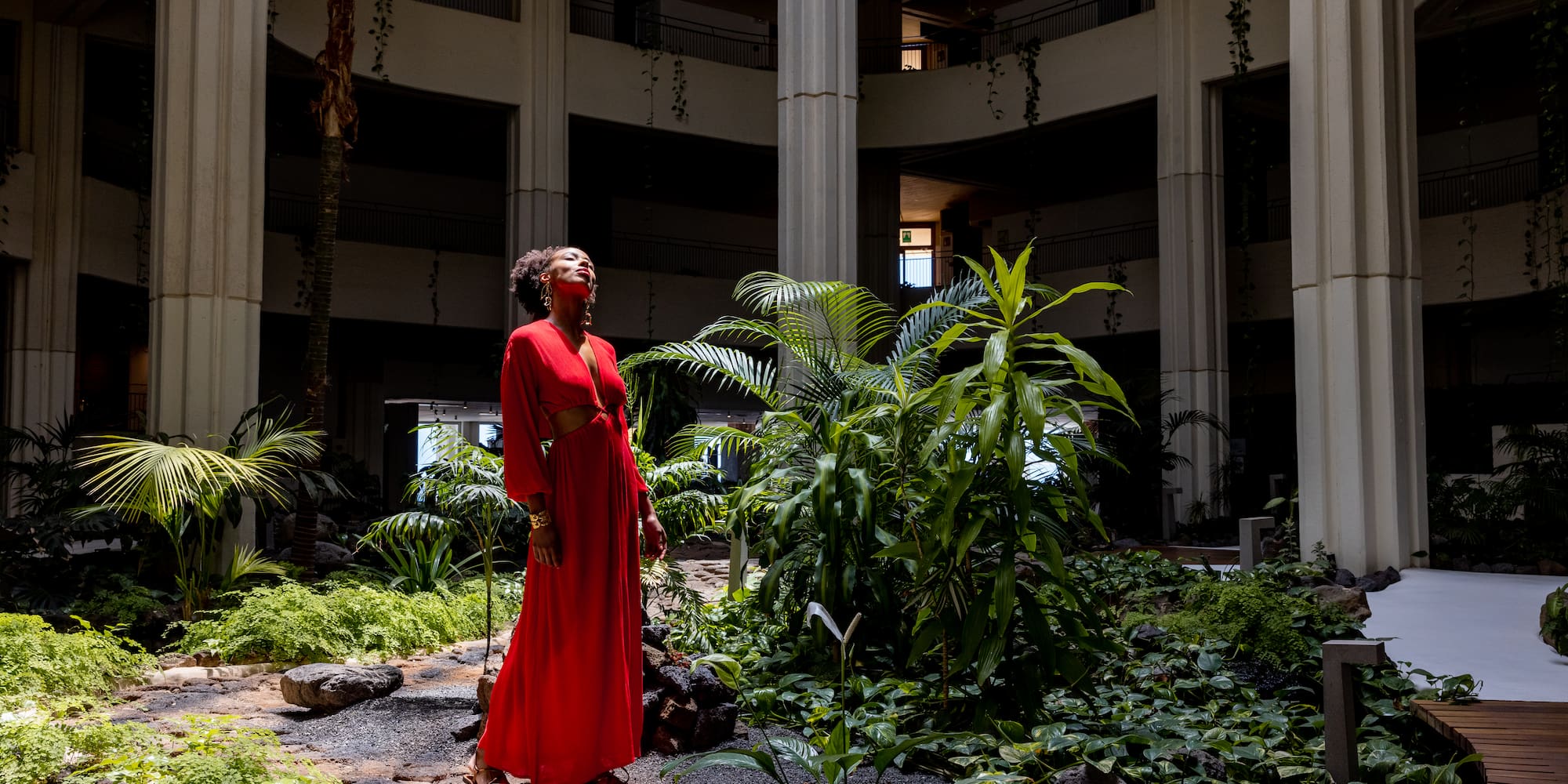 a woman in a red dress in a courtyard with plants
