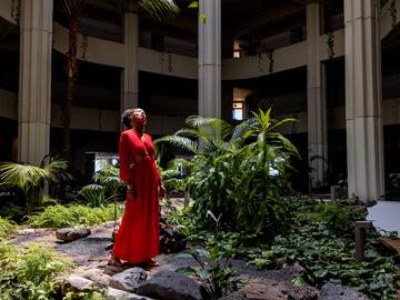 a woman in a red dress in a courtyard with plants