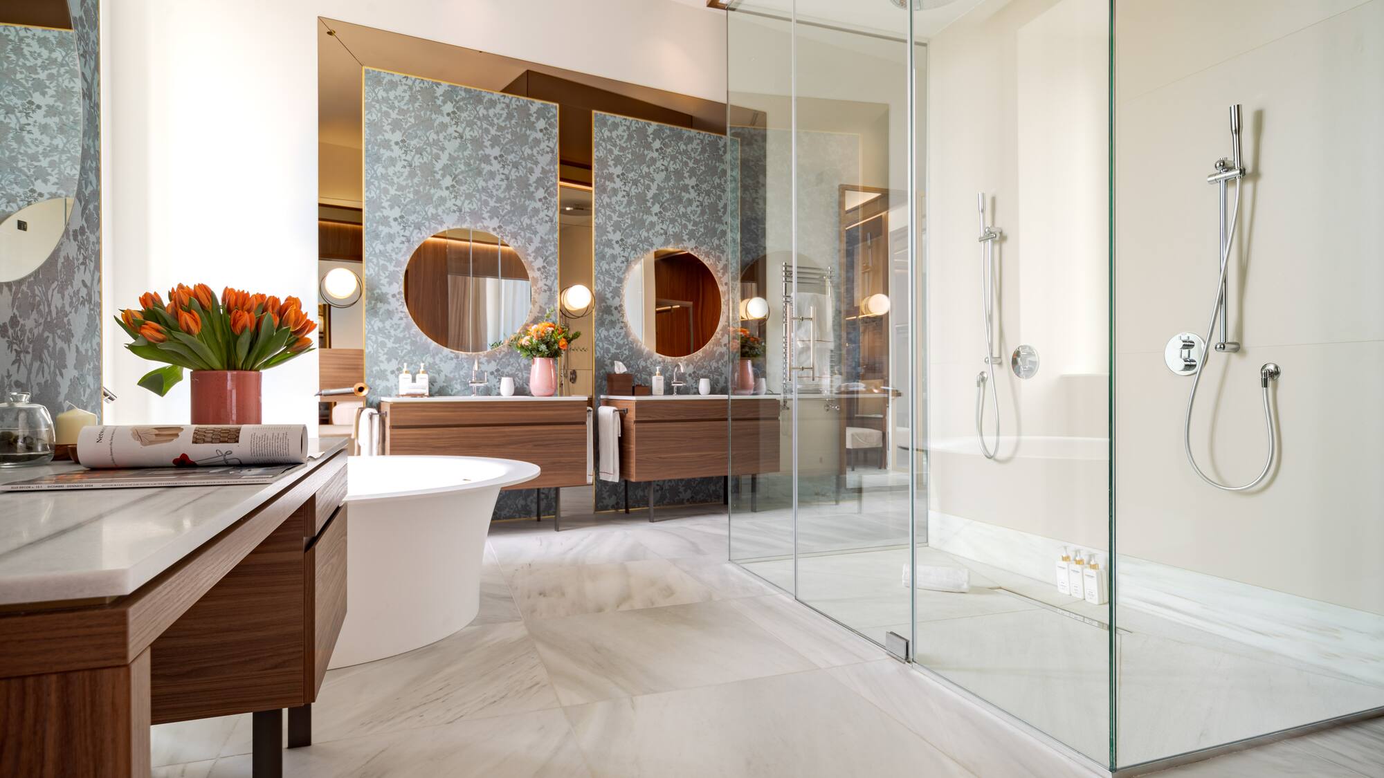 a bathroom with a glass shower and a tub
