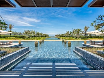 a pool with water and trees in the background