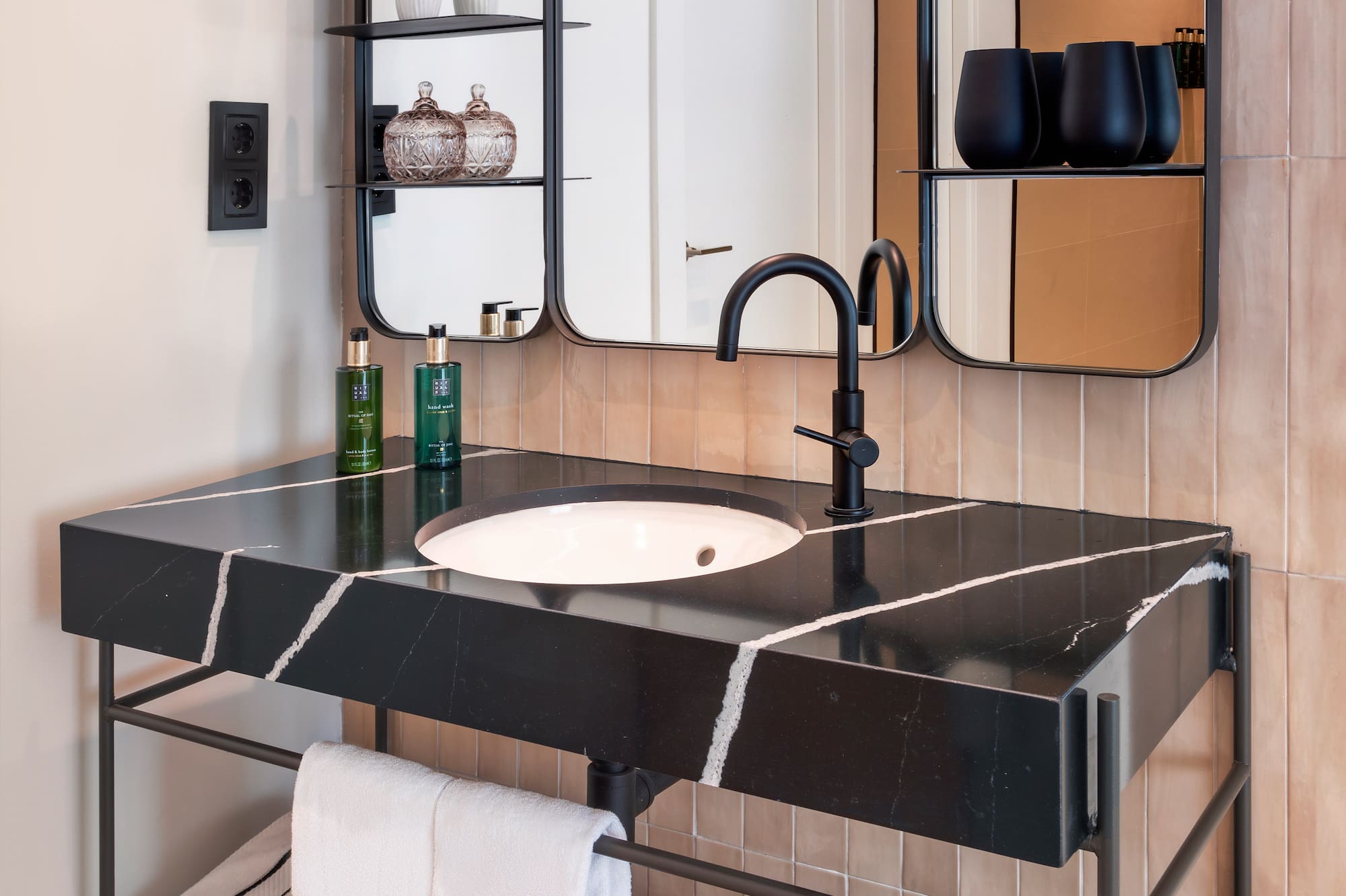 a bathroom with a black sink and mirror