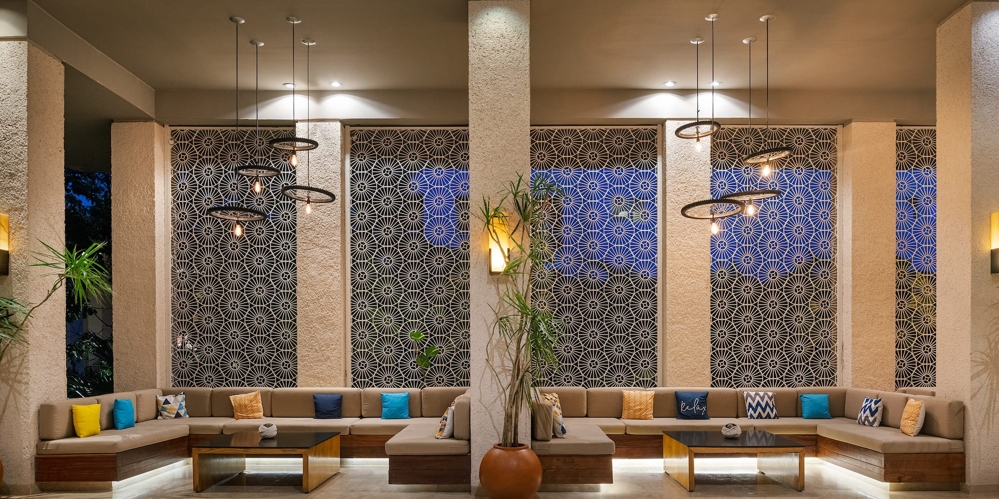 a room with a large couch and a plant in a pot